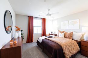 Las Vegas apartment for rent - a bedroom with a bed and a dresser and a ceiling fan at EVERETT APARTMENT HOMES, Las Vegas, NV, 89113