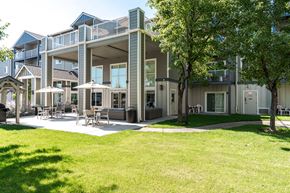 Bend apartment for rent - A large building with a green lawn in front.