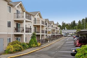 Burien apartment for rent - A row of apartment buildings with a parking lot in front.