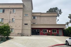 Los Angeles apartment for rent - the front of a building with a driveway and a bike parked in front