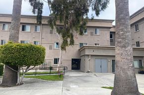 Los Angeles apartment for rent - an apartment building with a sidewalk and palm trees