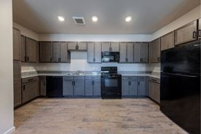 Reno apartment for rent - an empty kitchen with black appliances and wooden cabinets at Springview by Vintage, NV, 89512