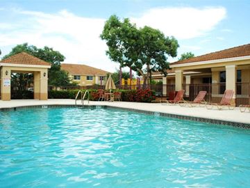 Miami apartment for rent - a swimming pool in front of a house with a resort style pool