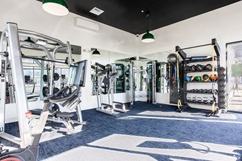 A fitness room with cardio equipment and weights