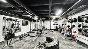 Salt Lake City apartment for rent - A gym with a variety of equipment including weights and a tire.