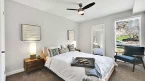 Salt Lake City apartment for rent - A bedroom with a large bed, a ceiling fan, and a chair.