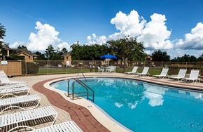 Crestview apartment for rent - A pool surrounded by white chairs and a fence at ADDISON PLACE, CRESTVIEW