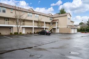 Vancouver townhouse for rent - a car parked in a parking lot in front of an apartment building at Quail Run Apartments, Vancouver, Washington