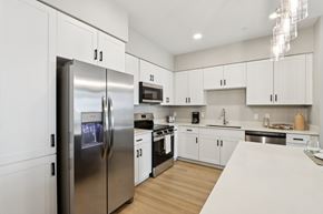 Maricopa apartment for rent - A modern kitchen with a stainless steel refrigerator and white cabinets at Ironwood Ranch Apartments,Arizona