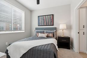 Maricopa apartment for rent - A bedroom with a bed, nightstand, and a picture frame on the wall at Ironwood Ranch Apartments,Maricopa,AZ,85138
