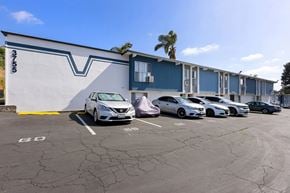 La Mesa apartment for rent - A parking lot with cars parked in front of a building with a blue and white exterior.