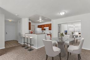 Orlando apartment for rent - A modern kitchen with a dining table set up with chairs at The Villages on Millenia Apartments, Florida