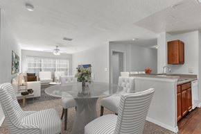 Orlando apartment for rent - A modern dining room with a glass table and striped chairs at The Villages on Millenia Apartments, Orlando