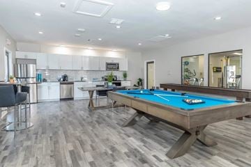 Las Vegas apartment for rent - A pool table in a room with a kitchen in the background.