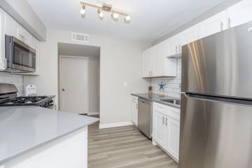 Las Vegas apartment for rent - A modern kitchen with stainless steel appliances and white cabinetry.
