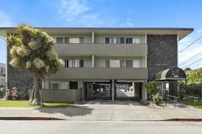 Alameda apartment for rent - A modern building with a flat roof and a stone wall on the side.
