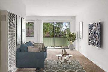 Alameda apartment for rent - A living room with a grey couch and a large window.