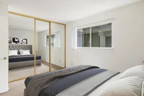 Alameda apartment for rent - A bedroom with a bed, a mirror, and a window.