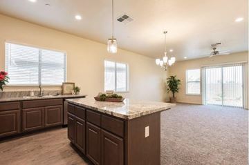 Modesto apartment for rent - A kitchen with brown cabinets and a marble countertop.