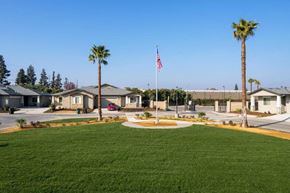 Modesto apartment for rent - a flag pole with an american flag in the middle of a grassy area
