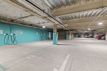 A parking garage with a blue wall and a green pillar.