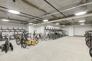 A bike storage room with many bikes on racks.