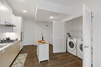 A kitchen with a washing machine and dryer in the laundry room.