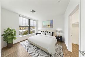Newton apartment for rent - A bedroom with a large bed and a painting on the wall. at Trio Newton Apartments, Newton