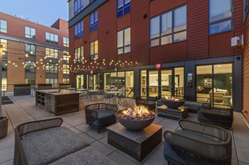 A patio with a fire pit and seating area.