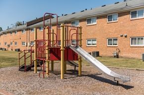 Chesapeake apartment for rent - a slide in a playground in front of a brick building