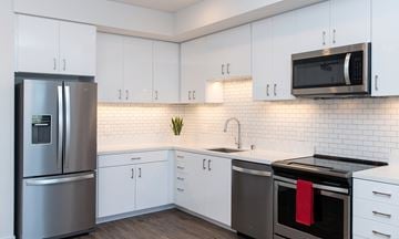 Oakland apartment for rent - A modern kitchen with white cabinets and a stainless steel refrigerator.