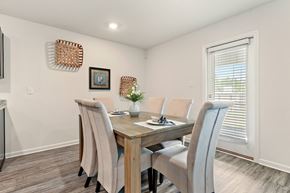 Ocean Springs apartment for rent - Dining room with wooden table, six upholstered chairs, and decorative wall baskets.