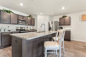 Ocean Springs apartment for rent - Modern kitchen with granite island, stainless steel appliances, and dark wood cabinets.