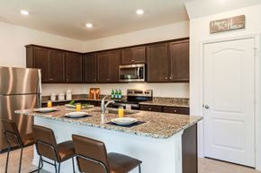 Jacksonville townhouse for rent - Modern kitchen with dark wood cabinets, stainless steel appliances, granite countertops, and island seating set for breakfast.