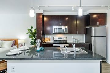 Raleigh apartment for rent - A modern kitchen with dark brown cabinets and a white island.