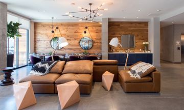 Oakland apartment for rent - A living room with a brown leather couch and a wooden wall.