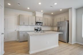 Charlotte townhouse for rent - A kitchen with white cabinets and a marble island.