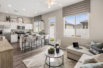 Phoenix apartment for rent - A modern kitchen with a dining table and chairs, a laptop on a sofa, and a coffee table in the center.