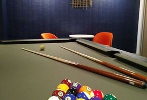New Rochelle apartment for rent - A pool table with a few balls and cues.