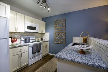 Custom cabinetry with designer hardware and tile backsplash