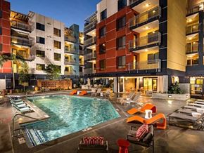 Long Beach apartment for rent - Long Beach, CA, Apartments with In-Unit Washer and Dryer - Urban Village -  Swimming Pool Surrounded by Lounge Seating, and Multi-Story Residential Buildings.