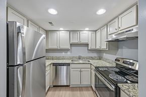 Raleigh apartment for rent - A modern kitchen with a stainless steel refrigerator and a granite countertop.