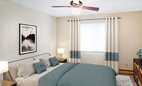 Coon Rapids apartment for rent - A bedroom with a bed, nightstand, and a ceiling fan.