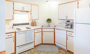 Coon Rapids apartment for rent - A kitchen with white appliances and wooden cabinets.