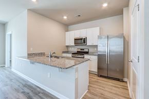 Myrtle Beach triplex for rent - a kitchen with a granite counter top and a stainless steel refrigerator