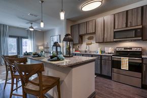 Jacksonville apartment for rent - Modern chef-inspired kitchen with granite countertops and stainless steel appliances at The Ridley Apartments on Beach Boulevard in Jacksonville, FL.