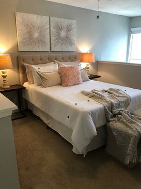Houston apartment for rent - A bedroom with a large bed and two lamps on either side.