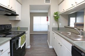 Houston apartment for rent - A kitchen with a black stove top oven and white cabinets.