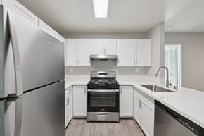 Henderson apartment for rent - A modern kitchen with a stainless steel refrigerator and white cabinets.