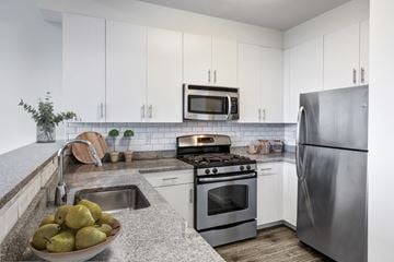 Stamford apartment for rent - a kitchen with white cabinets and stainless steel appliances
